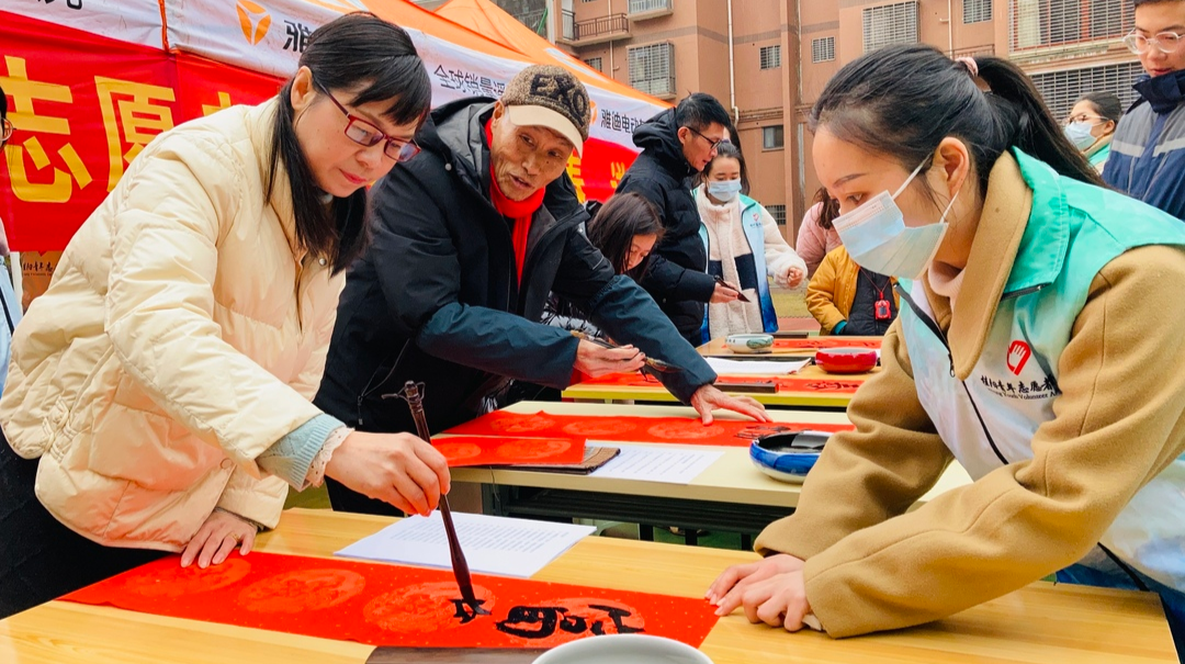 青年志愿者为居民写春联 送祝福