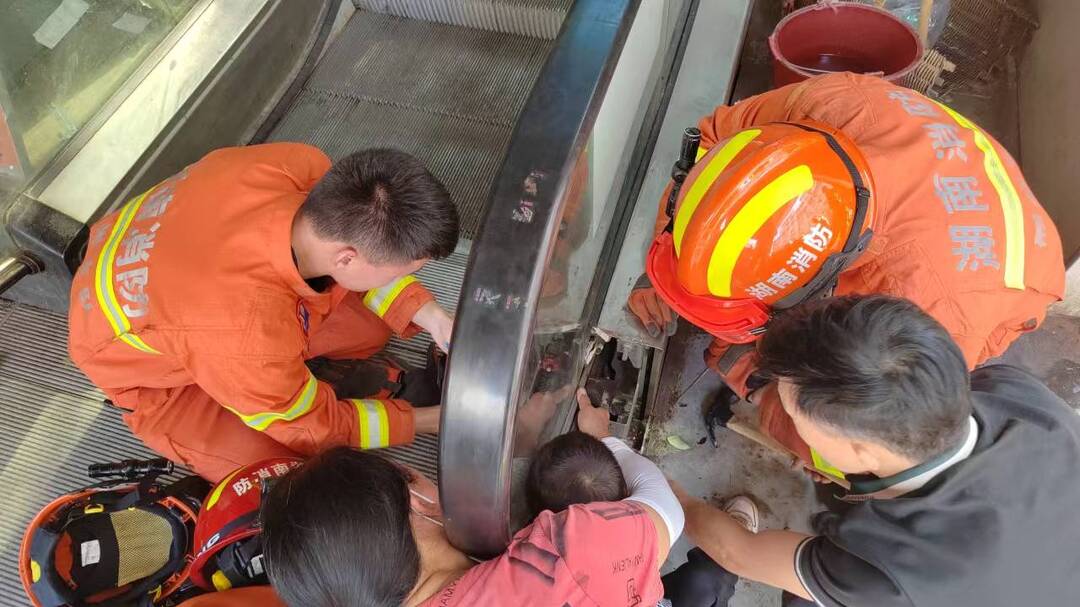 男孩手被卡电动扶梯 消防群众齐施救